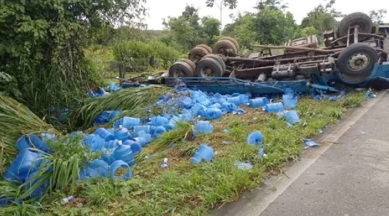 Motorista é resgatado após caminhão com galões de água capotar na BR-364